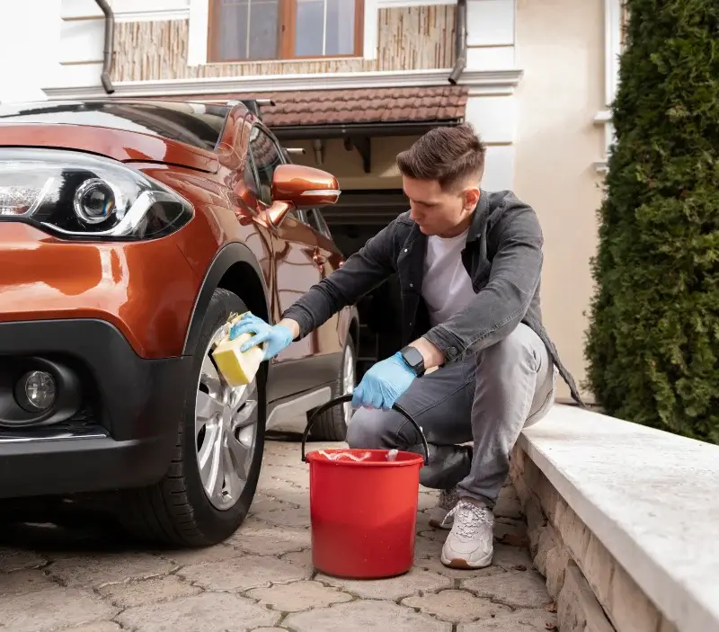 Lavage auto à domicile Castelnau-sur-Gupie : professionnel intervenant sur un véhicule